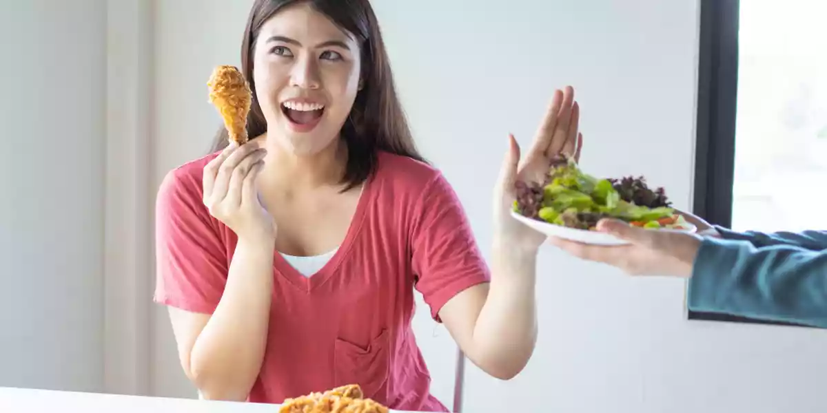 Woman refuses a salad instead of fried chicken full of trans fats