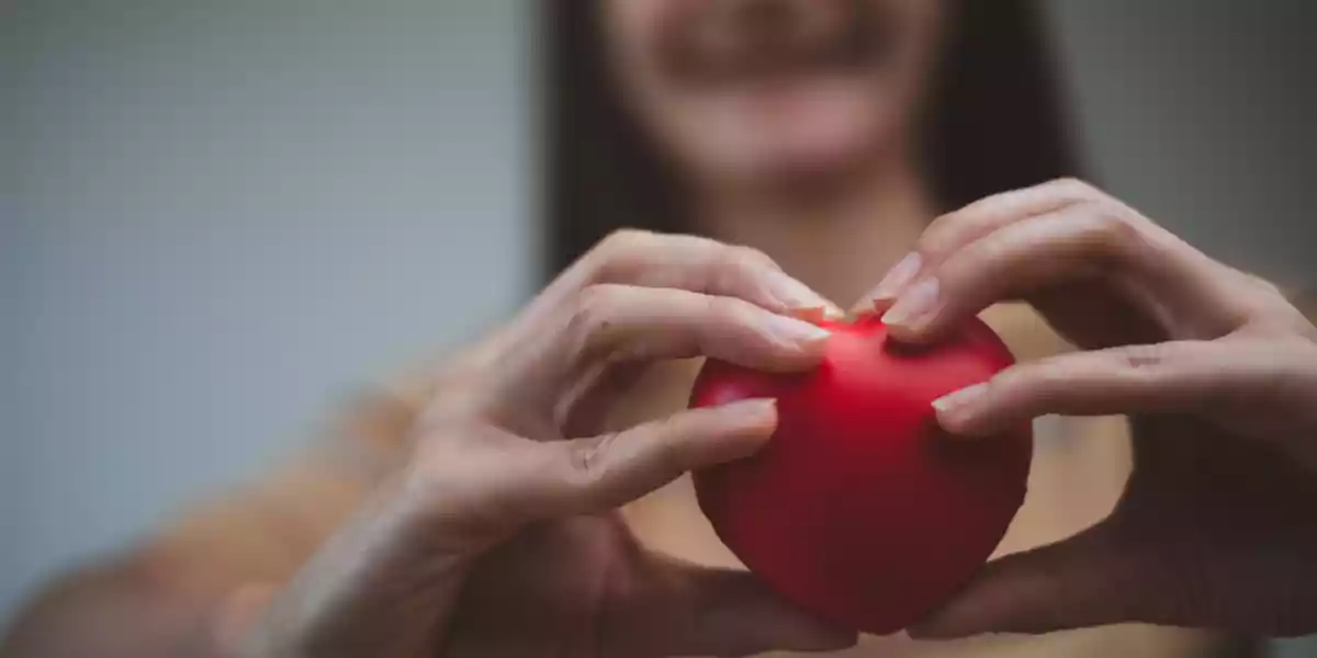 Woman with a heart shaped ball simulating her own